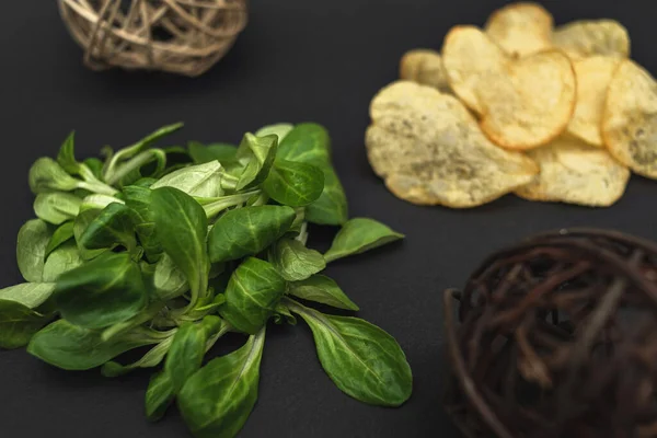 Salatblätter Und Chips Auf Schwarzem Hintergrund Gesunde Und Ungesunde Ernährung — Stockfoto