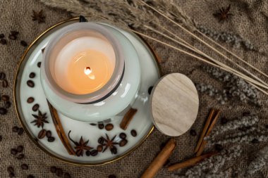 Çuval bezinden yapılmış mumlar, anason, tarçın çubukları ve kahve çekirdekleri. Kurumuş çiçeklerle süslenmiş.