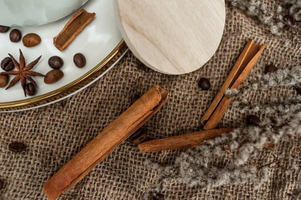 stock image Aesthetic composition of anise, cinnamon sticks and coffee beans on a platter against a background of burlap