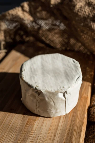 竹の板の上に白い型で丸みを帯びたチーズの頭の組成物は バラップの背景に 食品の審美的なサービス — ストック写真