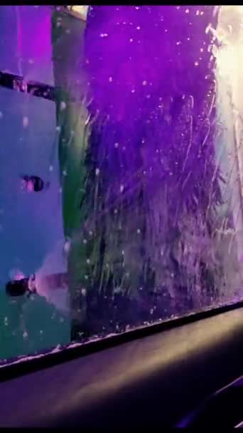 自动洗车 从车内看 彩灯和淡紫色泡沫倒在玻璃上 — 图库视频影像