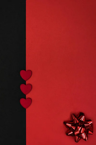 A simple black and red background for congratulations with a red bow and hearts, for Valentine\'s day or a wedding