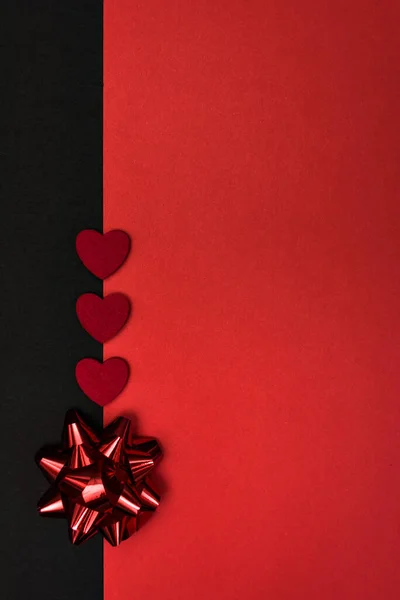 A simple black and red background for congratulations with a red bow and hearts, for Valentine's day or a wedding