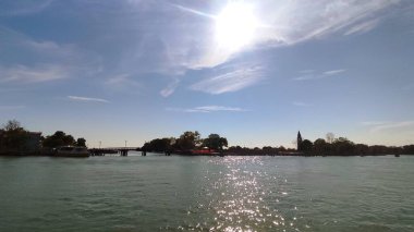 Tahta bir köprüye bağlanmış beyaz bir yatla İtalya, Venedik 'teki rıhtımın manzarası.