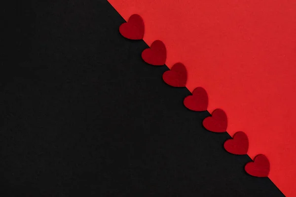 Black and red background, divided diagonally, decorated with red hearts