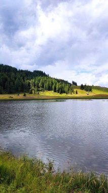 İtalya ve Avusturya sınırındaki Alpler 'de bir dağ gölü. Bulutlar ve mavi gökyüzüyle güneşli bir yaz günü. Dağ manzarası