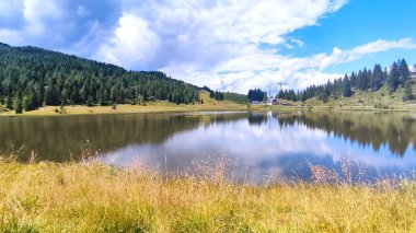 İtalya ve Avusturya sınırındaki Alpler 'de bir dağ gölü. Bulutlar ve mavi gökyüzüyle güneşli bir yaz günü. Dağ manzarası
