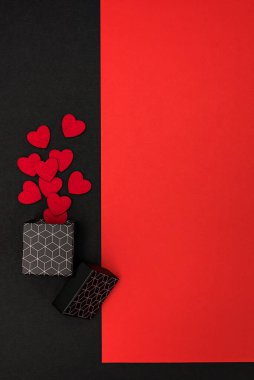 Geometrik desenli bir kutuyla kırmızı ve siyah zemin, arka plan kalplerle süslenmiş.