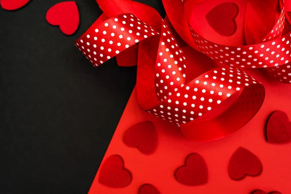 Black and red background with red ribbon and hearts. Banner with a place for the inscription