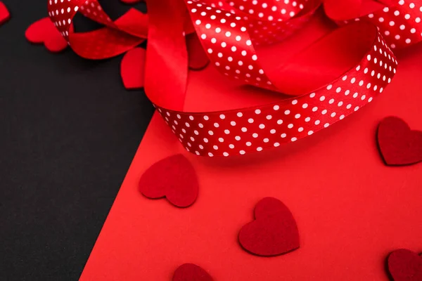 Black and red background with red ribbon and hearts. Banner with a place for the inscription