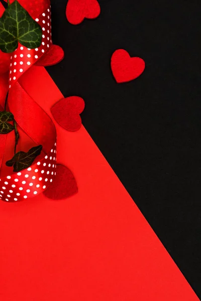 Background of the day congratulations on Valentine\'s Day, Happy wedding day, mother\'s Day. Black and red background with black gift box, geometric pattern, red polka dot ribbon, ivy leaves decorate