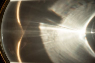 Reflection of light in a dish with a golden border. Light pattern on the plate