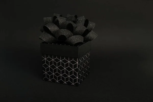 黑色礼品盒一种黑色礼品盒 有几何图案 黑色背景上有黑色蝴蝶结假日或折扣的最低限度背景 — 图库照片