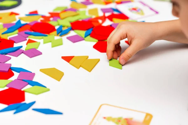 stock image Close up of kid hands playing bright wooden tangram toy. The child collects a pattern of wooden bars. Creative baby make new forms.