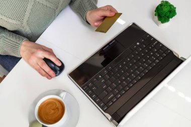 Masadaki bir kadın internette mal arıyor, bir online mağazada kredi kartıyla mal satın alıyor. Serbest çalışan kişi kredi kartıyla ödeme alır. Yemek siparişi vermek, bilet almak. Ev