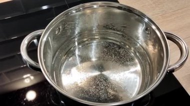 Çorba yapma süreci. Ev mutfağında yemek pişirmek için gerekli malzemeler bir tencereye konur. Kadının elleri kapalı.