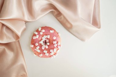 Beyaz arka planda, ipek kumaşlı, narin resimli bir çörek.