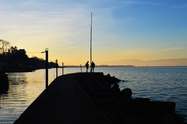 Siluety Dvou Mužů Molu Při Západu Slunce Jezero Geneva Evian — Stock fotografie