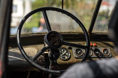 Eski paslı bir arabanın kabini. Eski terk edilmiş araba. Eski bir arabanın direksiyonu.