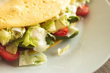 Ev yapımı doldurulmuş omlet taze sebze ve jambon, süzme peynirli. Kahvaltı için sağlıklı diyet yemeği. Lezzetli bir sabah ağacı. Üst manzara, düz uzanma.