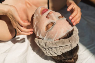 Yüz ve vücut bakımı. Sağlık, gençlik ve güzelliği koruma kavramı. Yüz maskeleri, modern kozmetoloji, güzellik uzmanı, eller. Güzellik teknikleri.