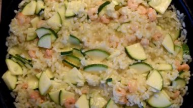İtalyan mutfağı. Kızartma tavasında karides ve kabaklı risotto. Pişirme işlemi. Kızartma tavası ve yakın plan pişmiş risotto.