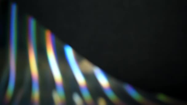 虹色の縞模様の多色形状 宇宙での虹の動き 多色のぼやけた縞と閃光を持つ抽象的な暗い背景 プリズムを通過する光のカラフルな遊び 空間の文字列 自然運動 — ストック動画