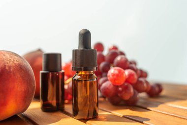 İki temel yağ savaşı. Cilt bakımı için doğal kozmetik. Ahşap bir masada şişe taze şeftali. Sağlık ve güzellikle ilgilenmek. Cilt bakımı için doğal kozmetikler.