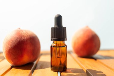 Gerekli yağların savaşı. Cilt bakımı için doğal kozmetik. Ahşap bir masada şişe taze şeftali. Sağlık ve güzellikle ilgilenmek