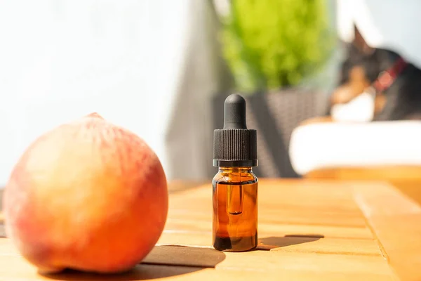 Stock image battle of essential oils. natural cosmetics for skincare. Bottle and fresh peaches on a wooden table. Taking care of health and beauty