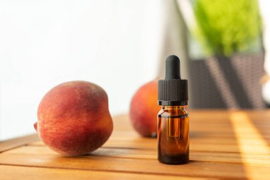 Gerekli yağların savaşı. Cilt bakımı için doğal kozmetik. Ahşap bir masada şişe taze şeftali. Sağlık ve güzellikle ilgilenmek