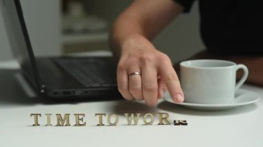 Tahta harflerdeki yazı çalışma zamanıdır. Bir kadın yazıyı yok eder. Çalışma gününün sonu kavramı.