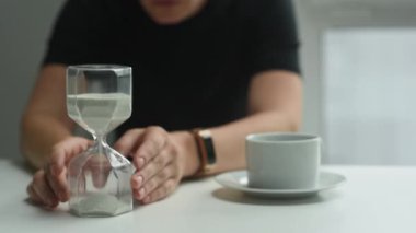 Bir kadın elindeki kum saatini çevirir ve zamanın akışını seyreder. Psikoloji, zaman kavramı tükeniyor.