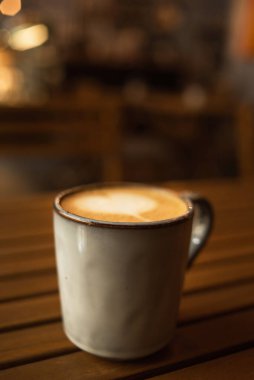 Ahşap bir masada kapuçino bardağı. Kil bardakta kahve. Cappuccino köpüklü bir kalp. Retro tarzı. Kopyalanacak yer