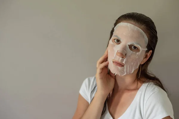 Donna Con Una Maschera Cosmetica Tessuto Sul Viso Cura Della — Foto Stock