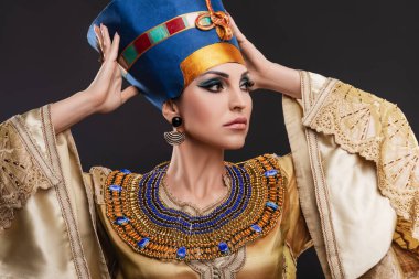 Kahverengi gözlü ve akşam makyajlı güzel bir kadın Kraliçe Kleopatra 'nın suretinde, taç, kolye