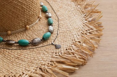Kadınlar hasır şapka, eski turkuaz boncuklar ve gümüş bir deniz kabuğu kolye ahşap masa, yaz aksesuarları