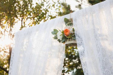 Tüylü düğün kemeri ve çiçekli kuş kafesi ve güneş ışığı