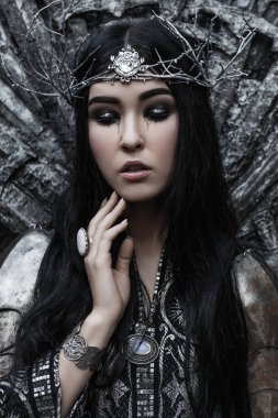 Güzel esmer kadın siyah ve gümüş elbiseli ve zırhlı. Süslü siyah saçlı, taç takan, fantezi kahramanı, kuzey efsanesi.