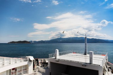 Gemiler ve tekneler limanda turkuaz suyun, yarımadanın, denizin ve şehrin, dağların ve gökyüzünün arka planında duruyorlar.