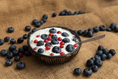 Sofrada yoğurt ve böğürtlen tabakları, kalın bir bez üzerinde, sağlıklı bir kahvaltı.