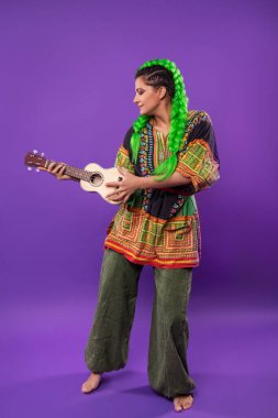 Açık yeşil saçlı, ukulele çalan hippi kadının stüdyo portresi.