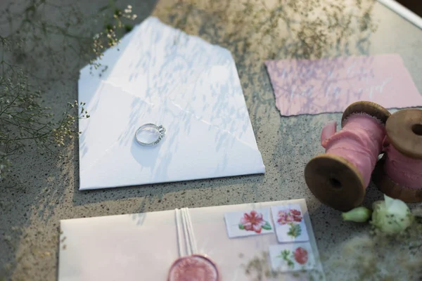 Белый Конверт Обручальным Кольцом Невесты Розовые Катушки Ленты Цветы Закат — стоковое фото