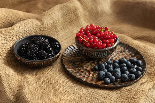 Teller Mit Saisonalen Beeren Auf Dem Tisch Auf Grobem Tuch — Stockfoto