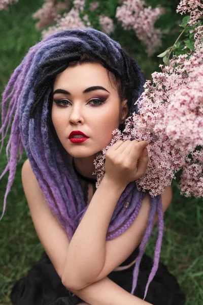 性感的年轻女子模特 头戴彩色假发 穿着粉色皮裤 站在淡紫色的春装肖像下 — 图库照片