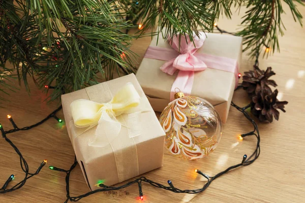 用黄色缎带 圆锥和木制桌子上的花环制作的圣诞礼物 — 图库照片