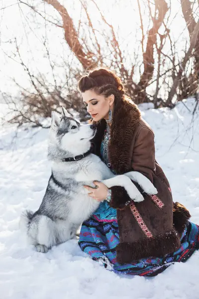 Vacker Brunett Kvinna Med Grå Husky Hund Sitter Snön Fläta — Stockfoto