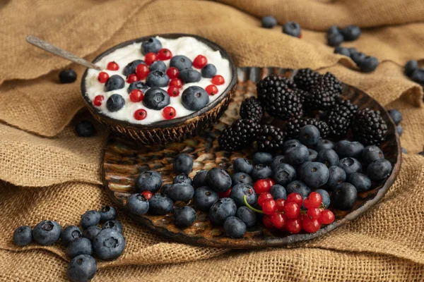 Teller Mit Joghurt Und Beeren Auf Dem Tisch Auf Grobem — Stockfoto