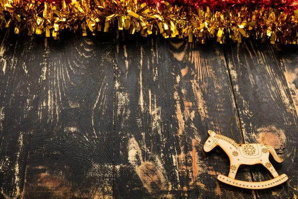 テキストのための場所が付いているクリスマスの平らな敷物 木のおもちゃの馬および黄金のテーブルに横たわる木製のテーブル — ストック写真