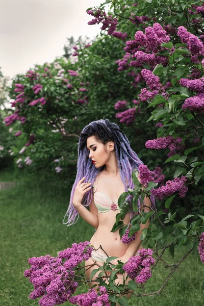色彩艳丽的年轻女子模特 站在紫丁香下 春装人像下 — 图库照片